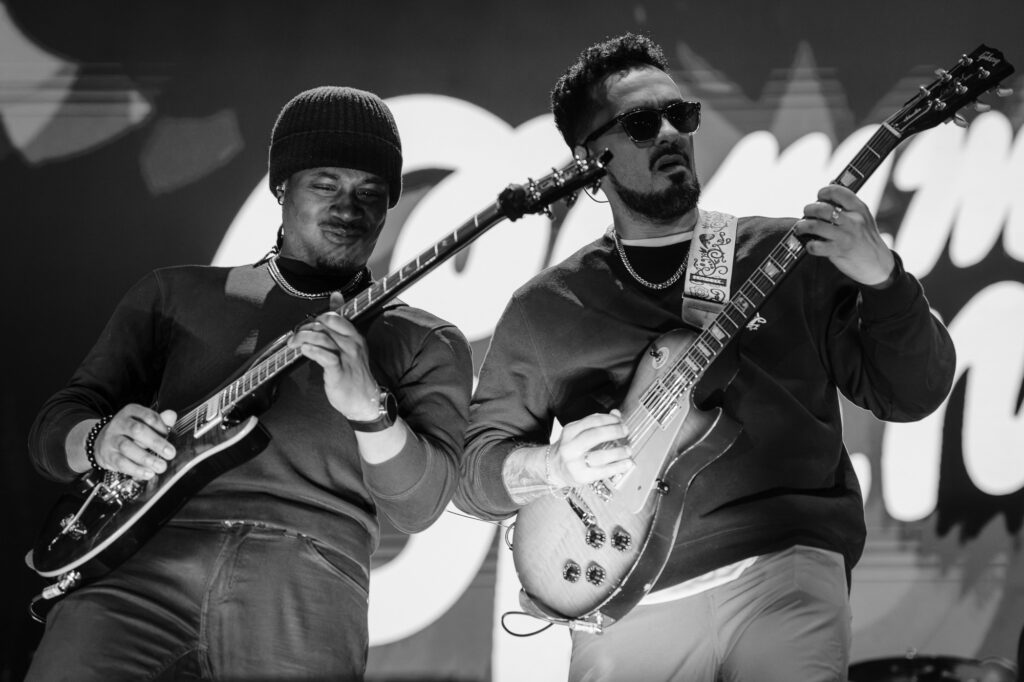 Common-Kings-Concert-Los-Angeles-May-23-2026-by-Zharmaaaine-76 – The 824 Journal Two male guitarists perform on stage, one in a beanie and the other in sunglasses, both playing electric guitars in a black-and-white shot.