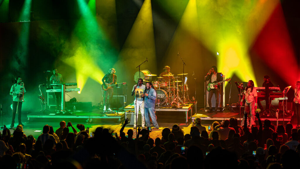 Stephen-Marley-Roots-and-Reggae-Concert-Pacific-Amphitheatre-OC-June-19-2026-20261869 – The 824 Journal Live concert scene with a full band onstage under green, yellow, and red lights; audience cheering in the foreground as phones capture footage