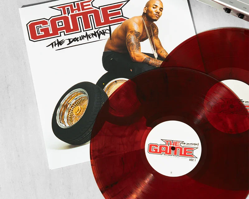 Red translucent vinyl record partially covering The Game: The Documentary album cover.