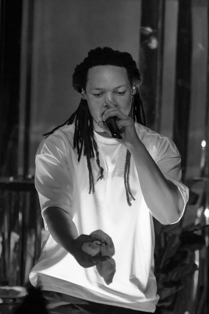 lack-and-white photo of Domani singing into the microphone during the Succession Tour at The Echo in Los Angeles.