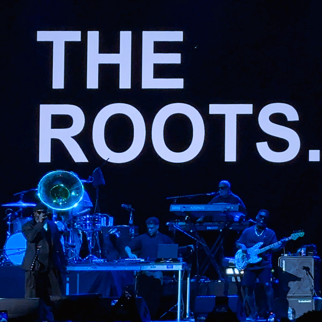 The Roots performing beneath their illuminated name at F&M Bank Amphitheater of Long Beach.