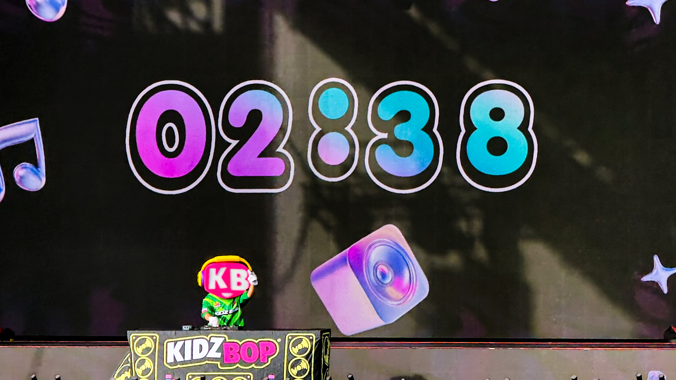 KIDZ BOP mascot DJ in front of the pre-show countdown on the video screen