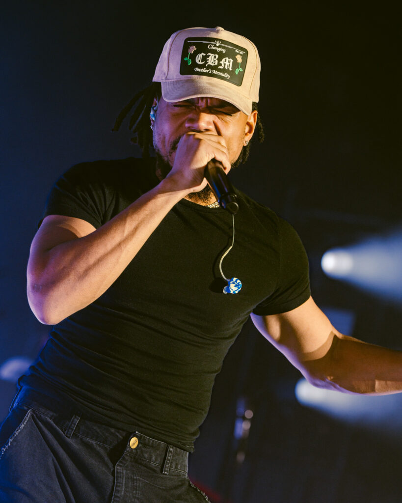 Chance the Rapper at Hollywood Palladium, Los Angeles, September 20, 2026 (18) – The 824 Journal Chance the Rapper smiling on stage in a beige trucker cap and black T-shirt under blue lights at the Hollywood Palladium.