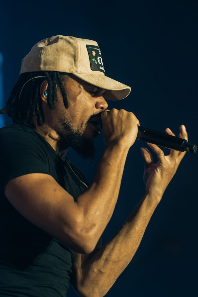 Chance the Rapper at Hollywood Palladium, Los Angeles, September 20, 2026 (21) – The 824 Journal Chance the Rapper at the Hollywood Palladium: close-up of Chance the Rapper singing into a microphone held with both hands at the Hollywood Palladium, beige cap.