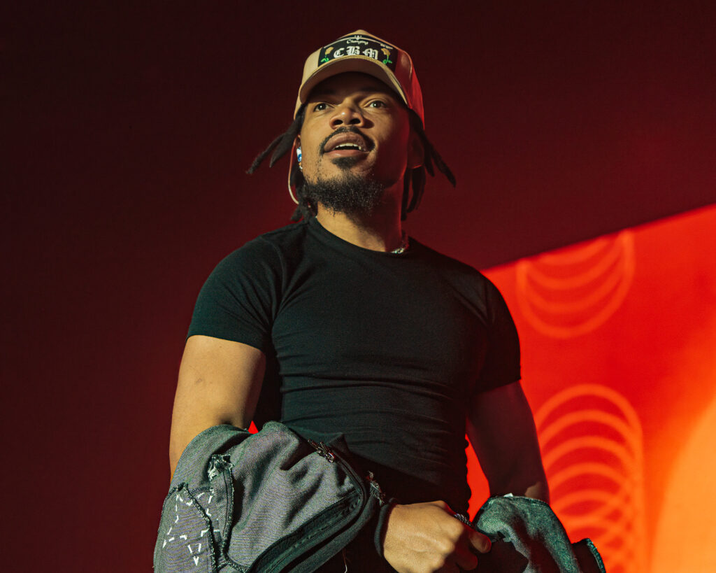 Chance the Rapper at Hollywood Palladium, Los Angeles, September 20, 2026 (3) – The 824 Journal Chance the Rapper smiling and holding a denim jacket against a red backdrop at the Hollywood Palladium.