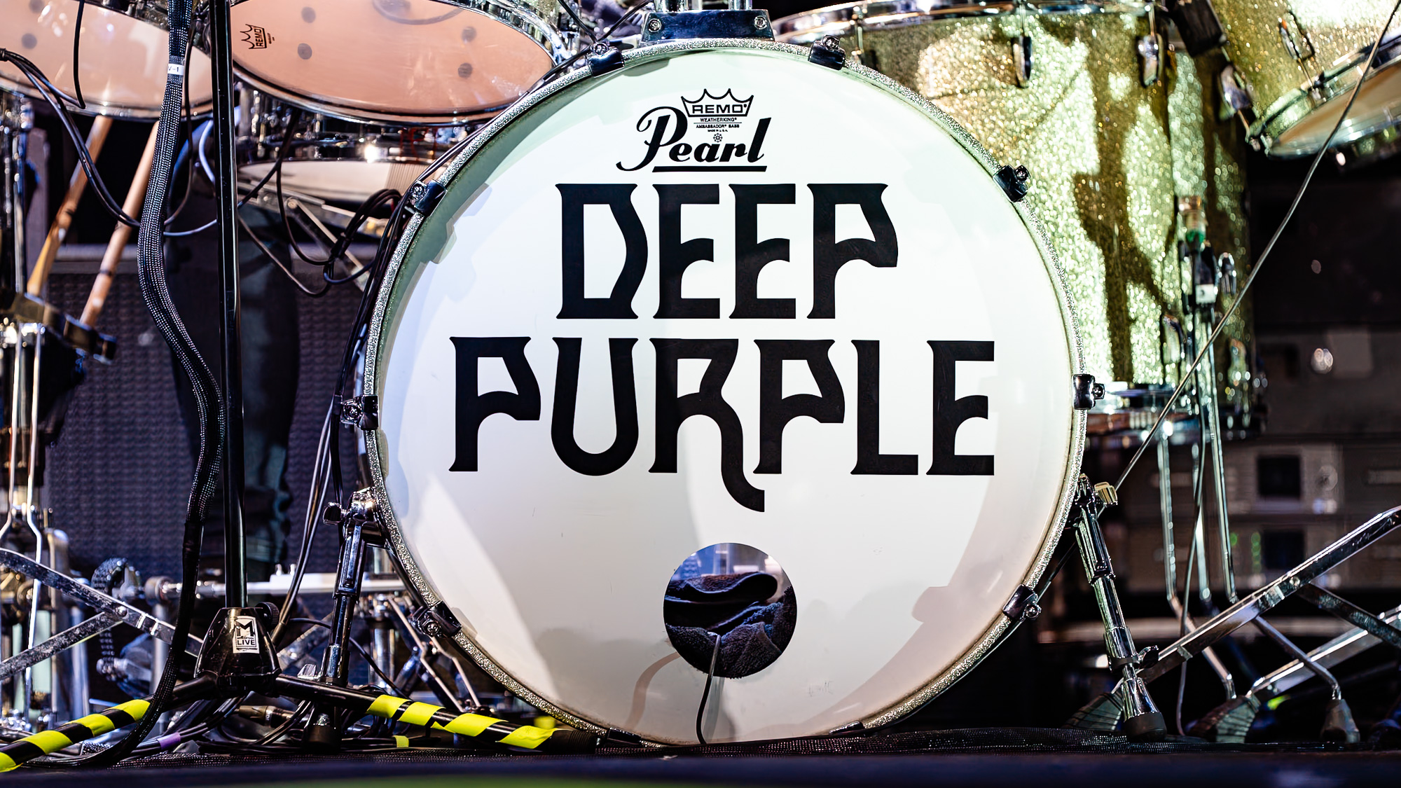 Deep Purple at F&M Bank Amphitheater in Long Beach: close-up of a Pearl bass drum head with the Deep Purple logo, surrounded by drums and stage gear.