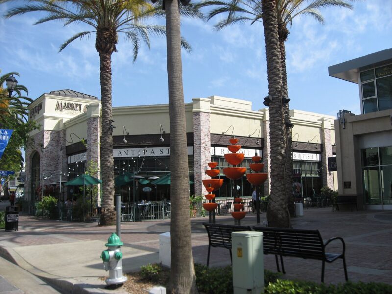 Palm trees and restaurant storefronts around a plaza in downtown Brea, California