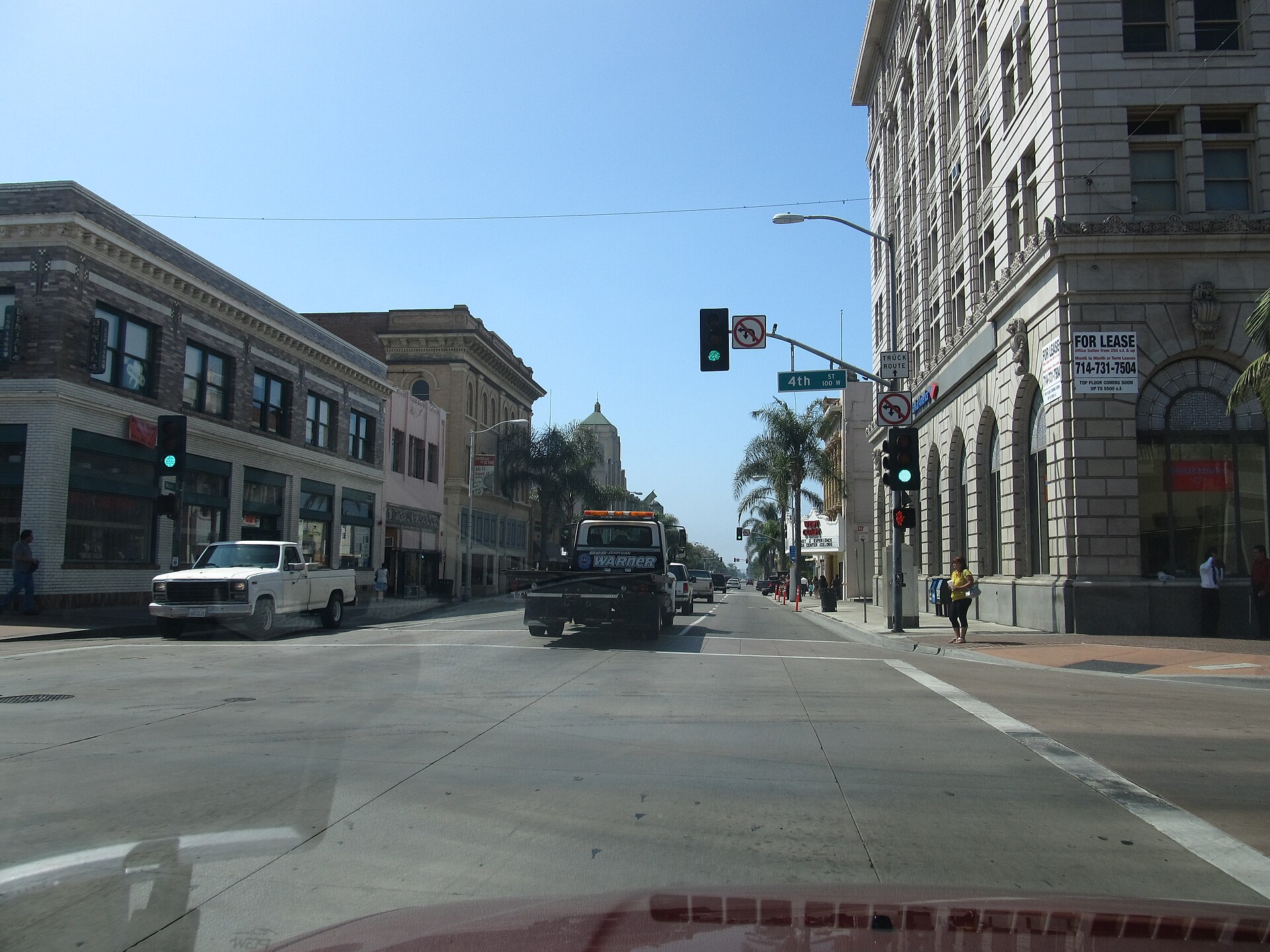 A downtown Santa Ana street lined with historic brick and stone buildings under a clear blue sky