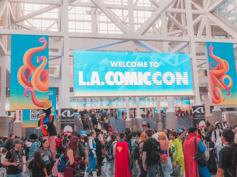 Crowds of fans, some in costume, gather under a large Welcome to L.A. Comic Con banner inside the Los Angeles Convention Center lobby