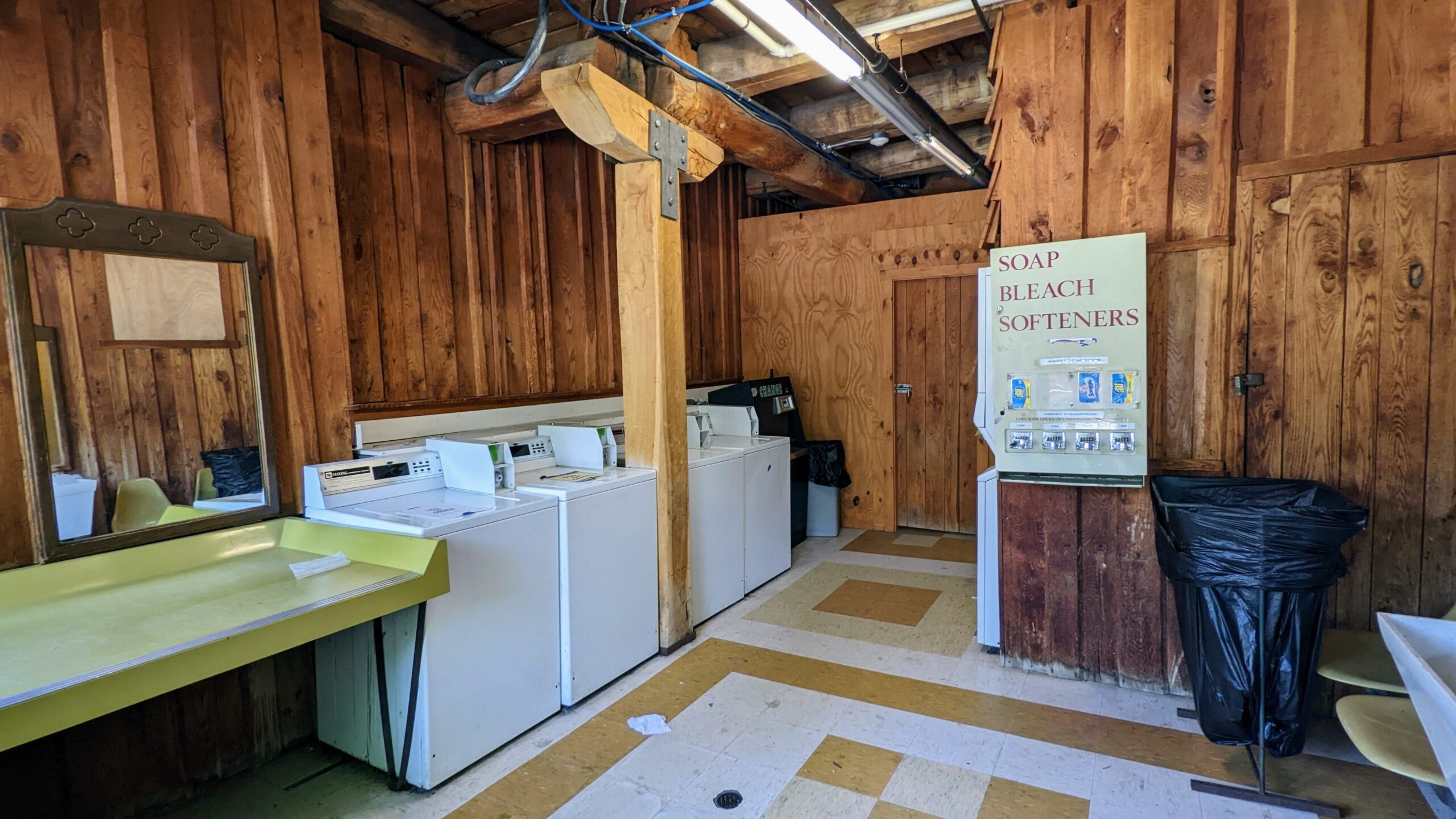 A row of front-loading washing machines in a laundromat