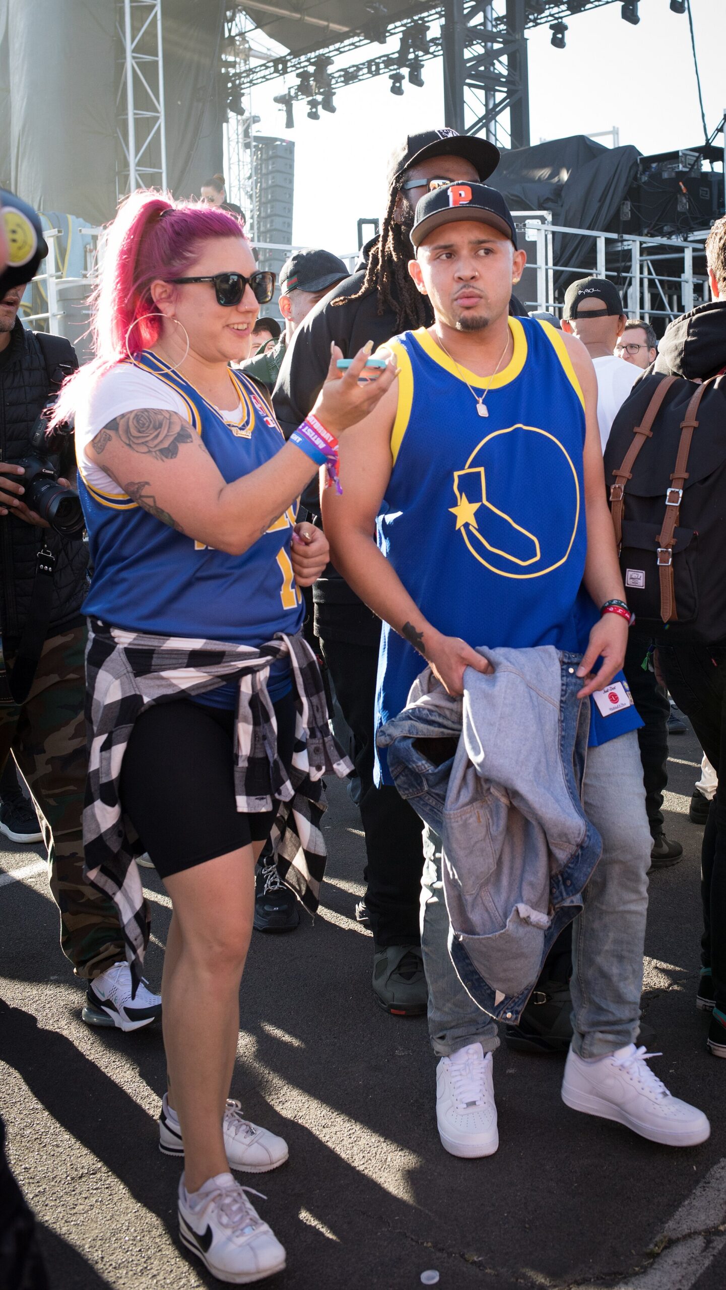 Two people standing at the side of the stage at Rolling Loud in Oakland in 2018, one of them rapper P-Lo