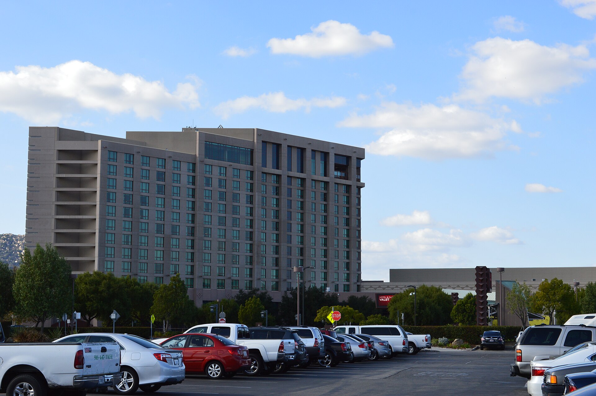 The tall hotel tower of Pechanga Resort Casino in Temecula rising above a parking lot under a partly cloudy sky