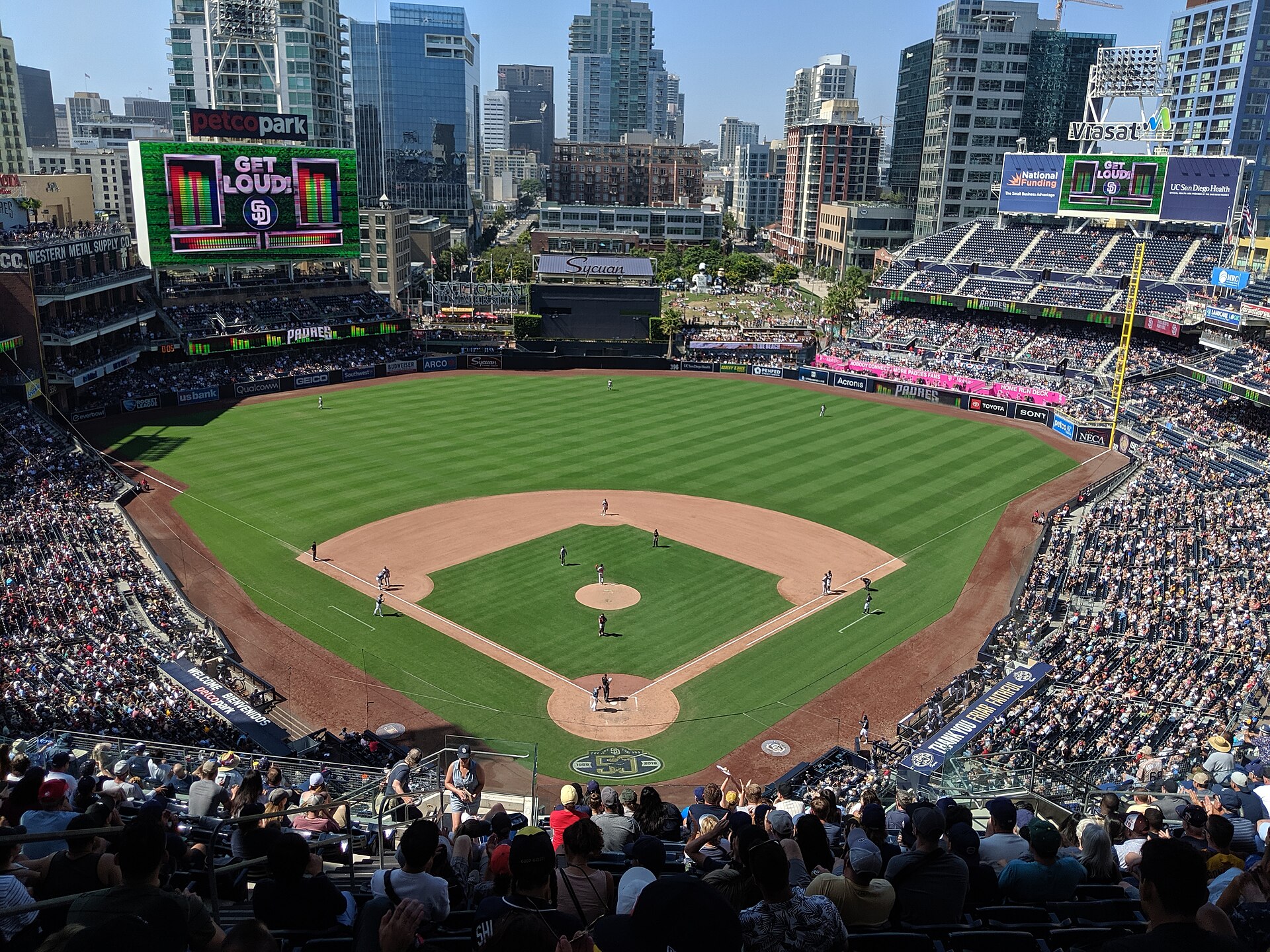 The field and packed seating bowl of Petco Park with the downtown San Diego skyline behind it