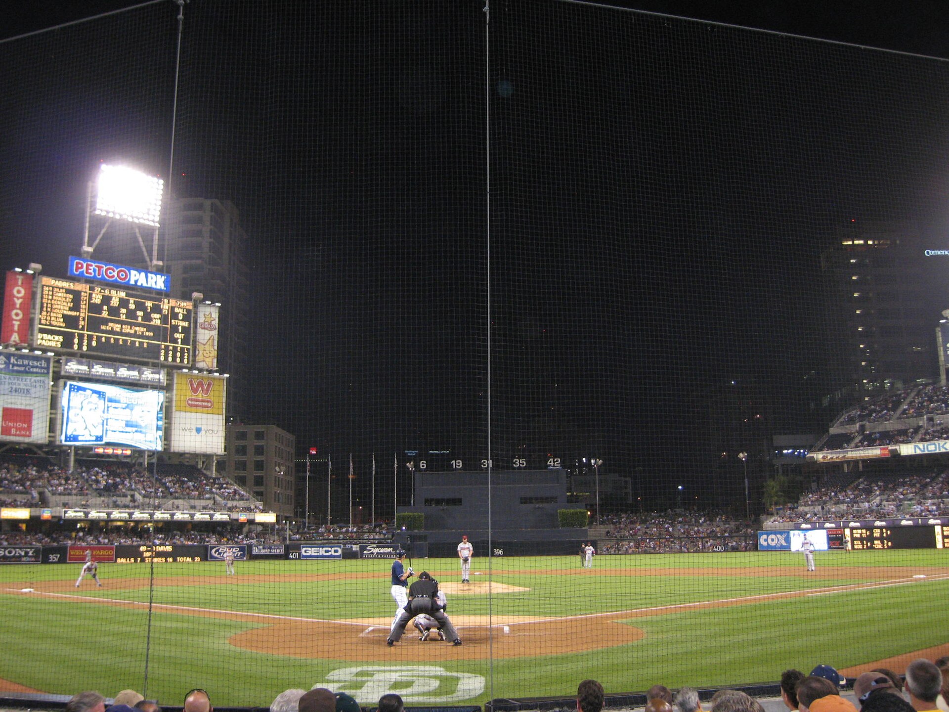 Petco Park lit up under stadium lights at night, seen from the stands