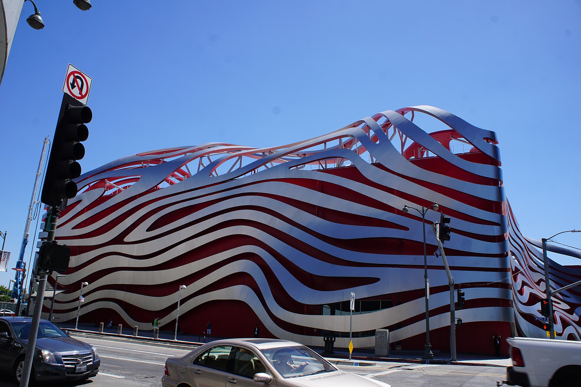 The red and silver steel ribbons of the Petersen Automotive Museum facade on Wilshire Boulevard in Los Angeles.