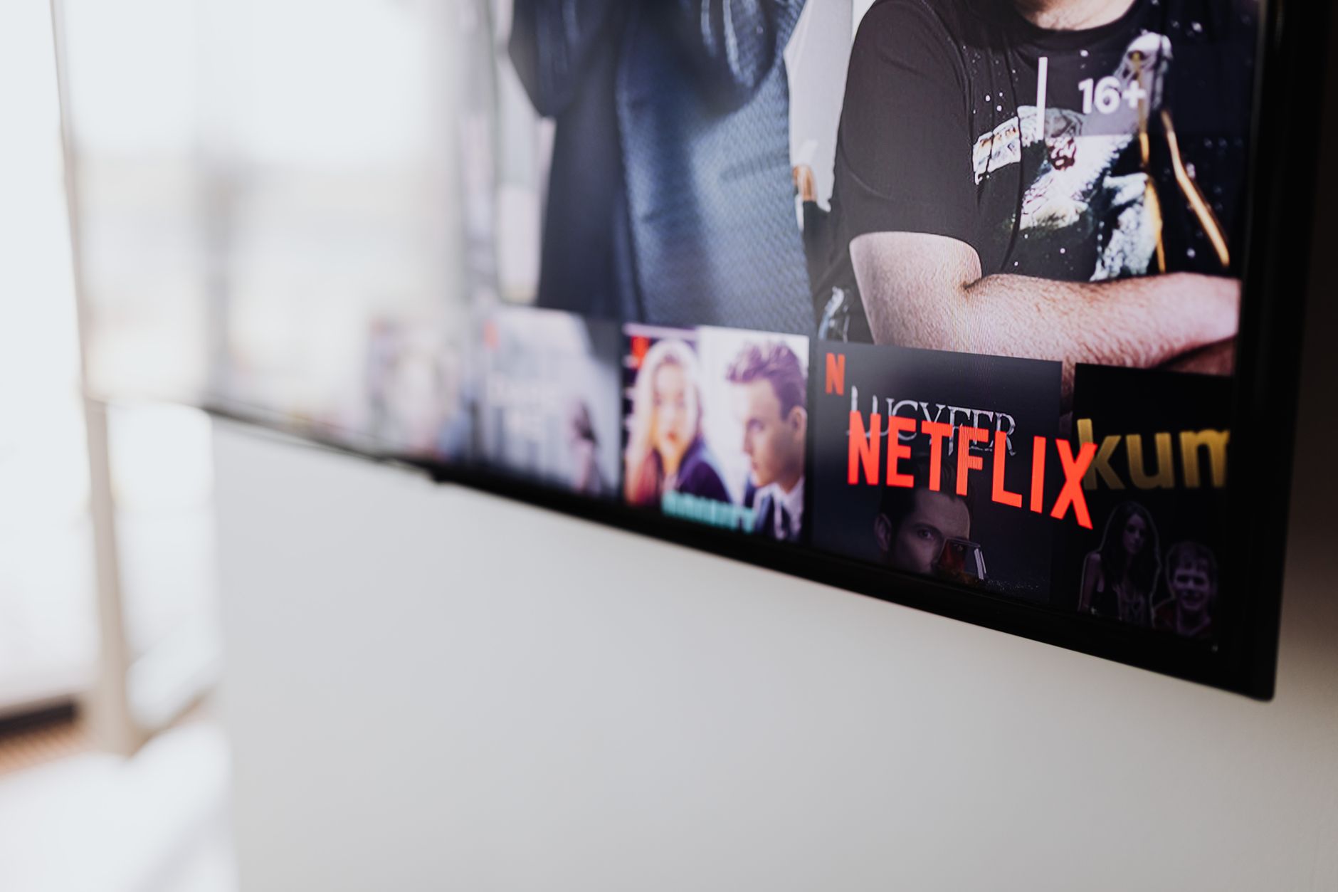 black flat screen tv turned on showing man in black shirt