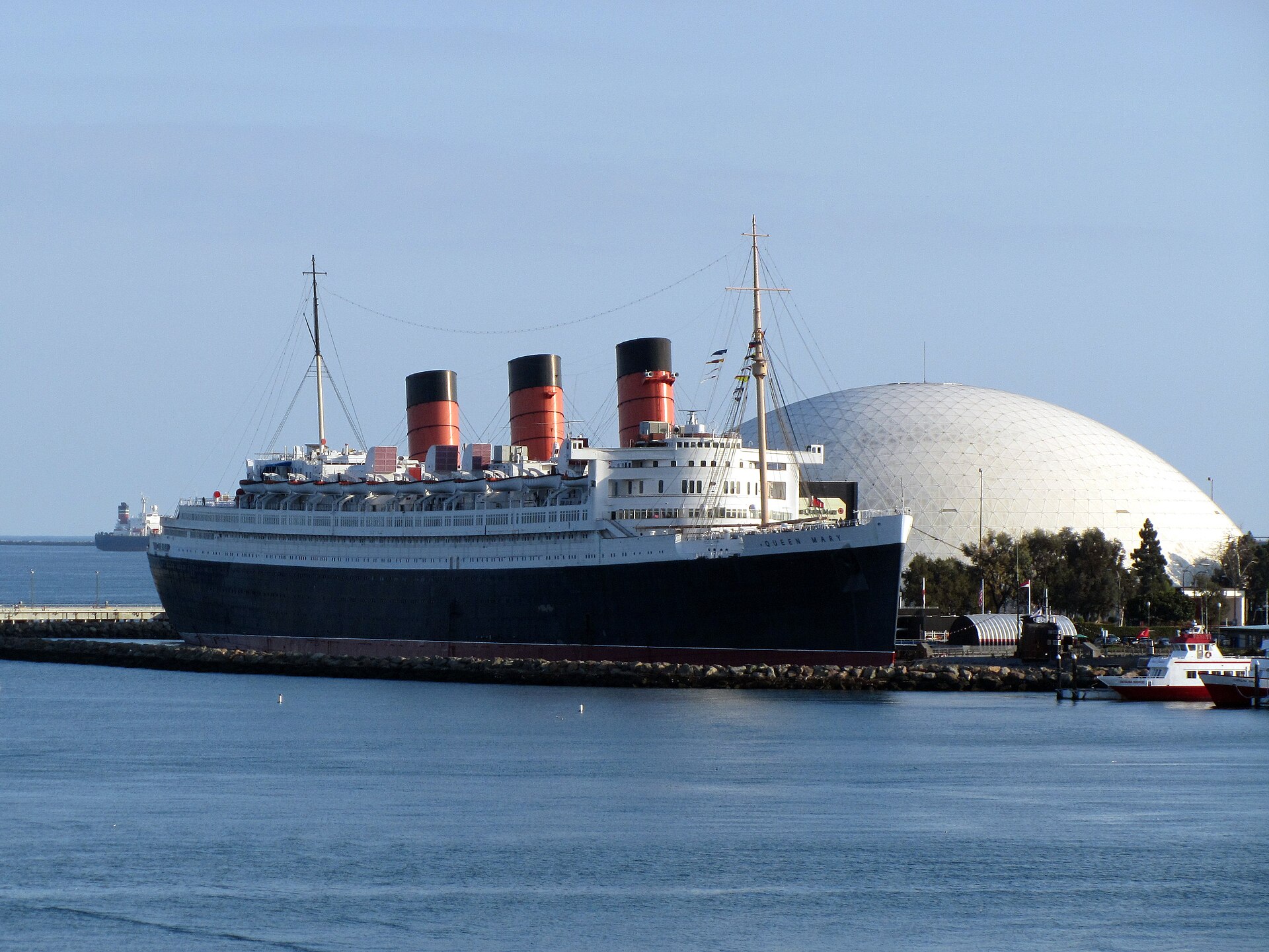 The Queen Mary ocean liner docked in Long Beach, with its three red funnels and the white dome beside it