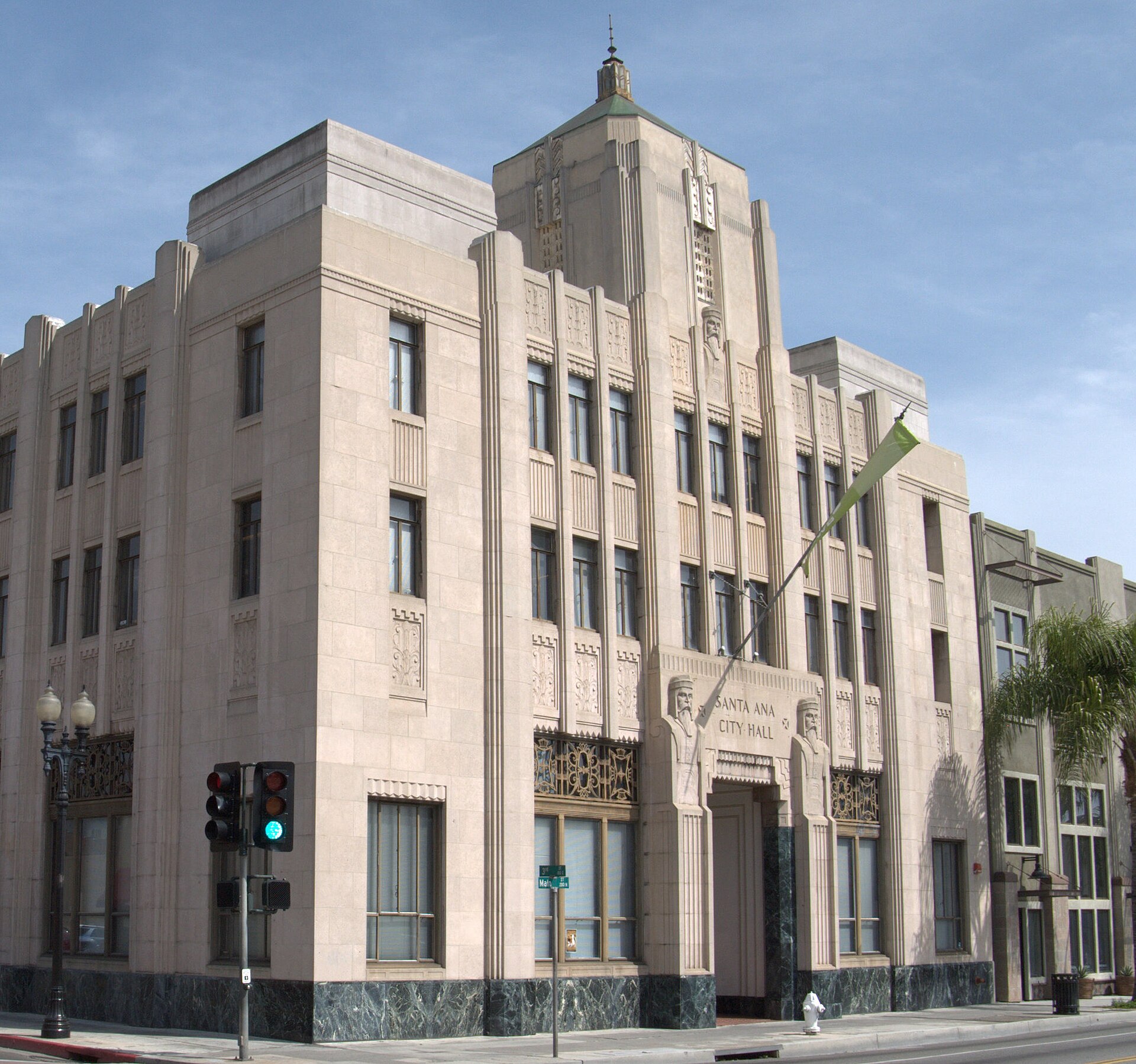 The pale stone facade of the 1935 Santa Ana City Hall building against a blue sky