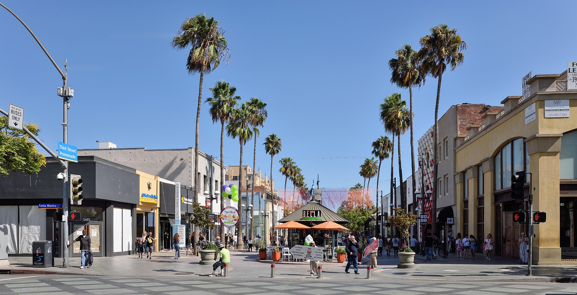 Pedestrians and palm trees along the Third Street Promenade in downtown Santa Monica on a sunny day