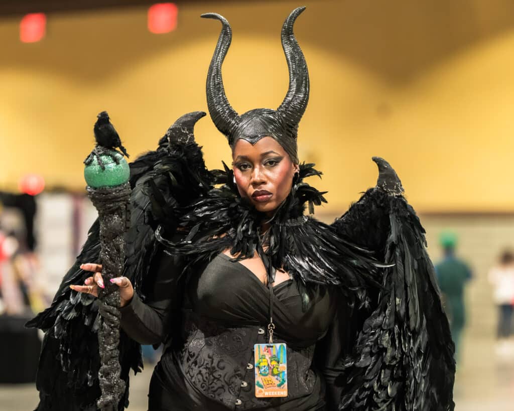 Zharmaine-Boatman-Long-Beach-Comic-Con-the8244journalpress-46926 – The 824 Journal Long Beach Comic Con 2026: person in a dramatic black feathered costume with large curved horn headpiece.