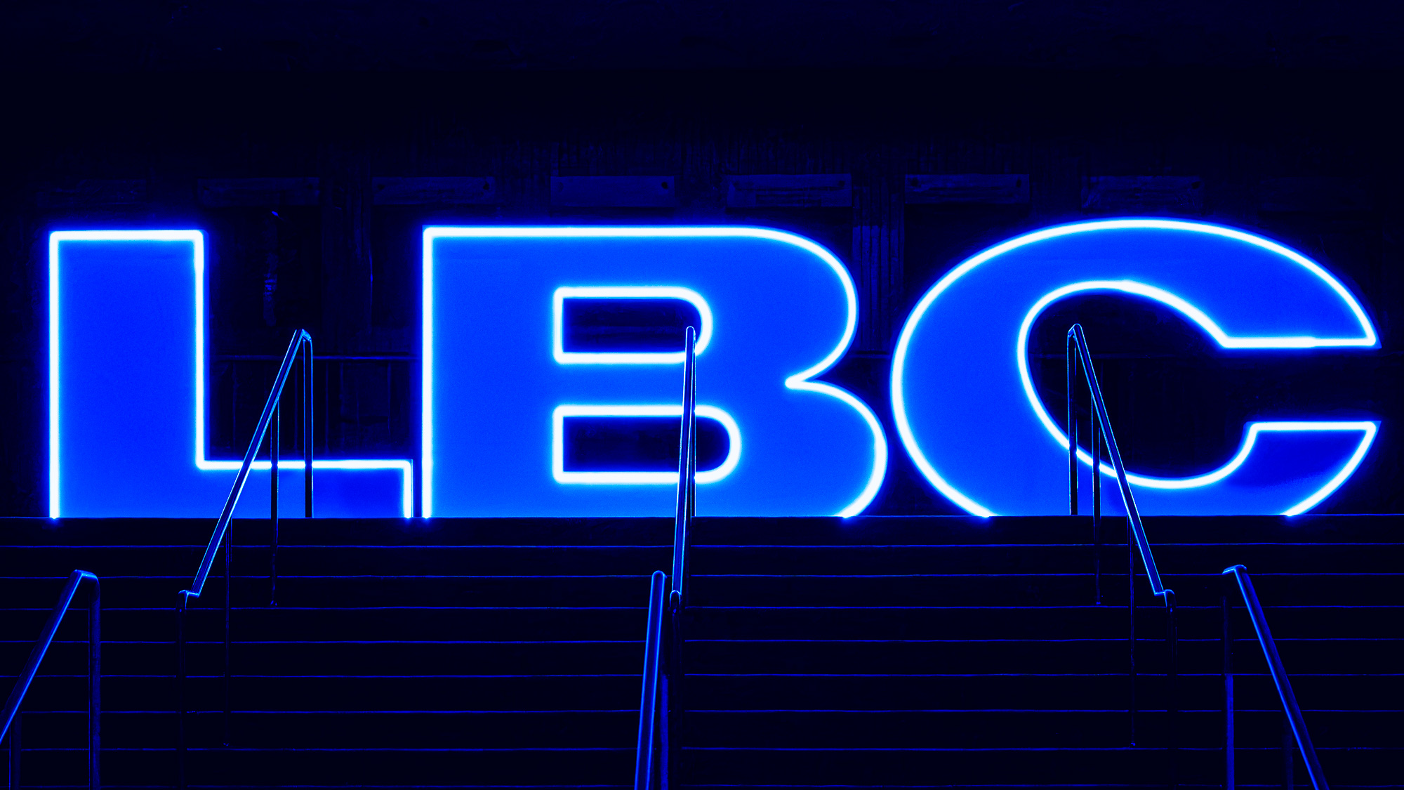 Illuminated LBC sign in blue light at Long Beach Comic Con 2026.