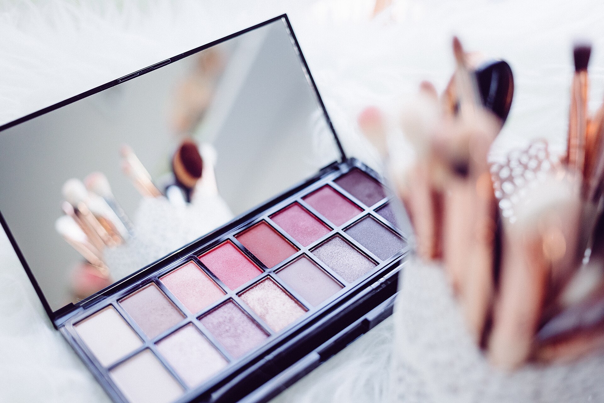 Makeup brushes and eyeshadow palettes on a table