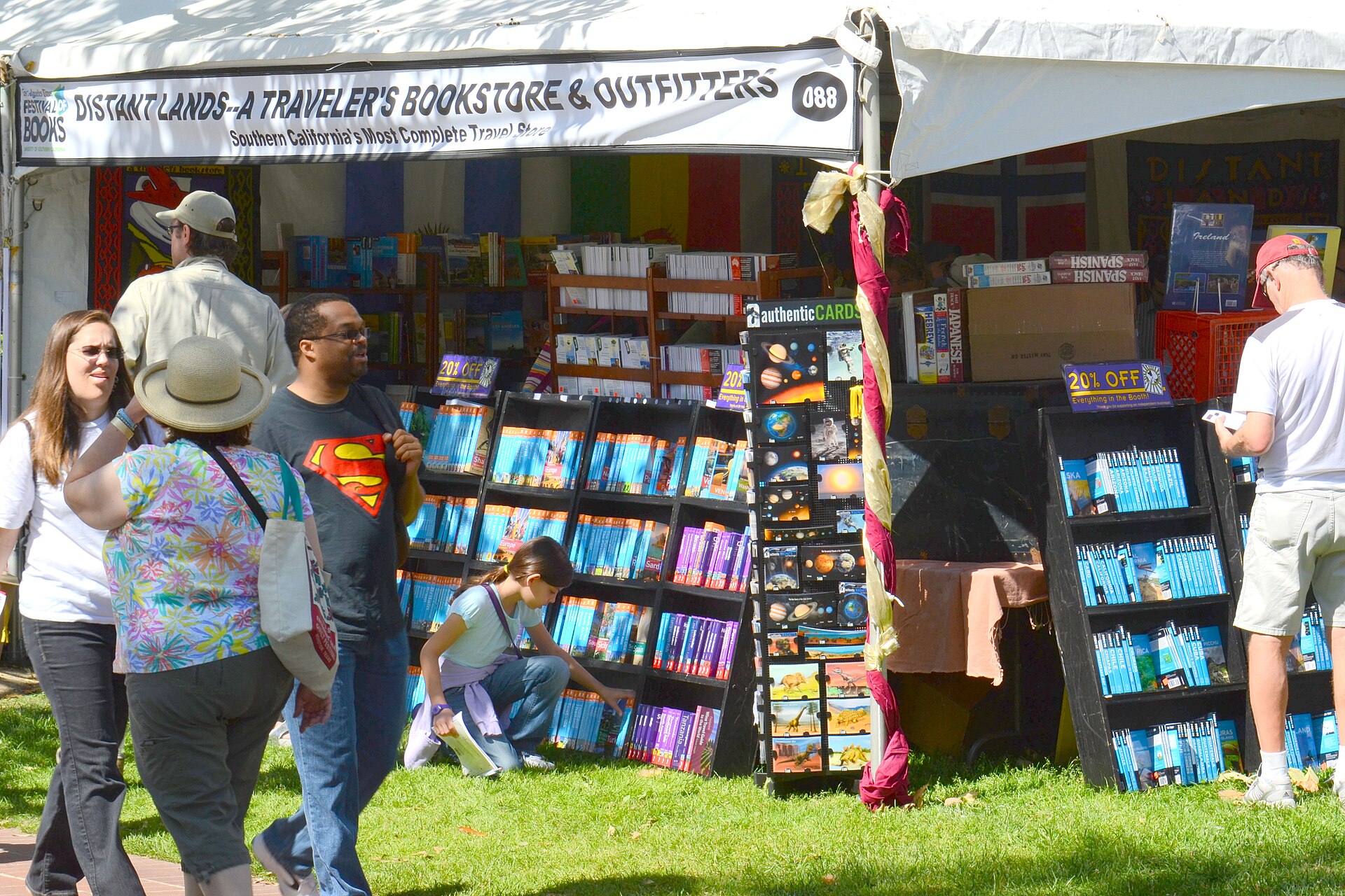 A bookseller's tent at the Festival of Books with tables of books and shoppers browsing outside