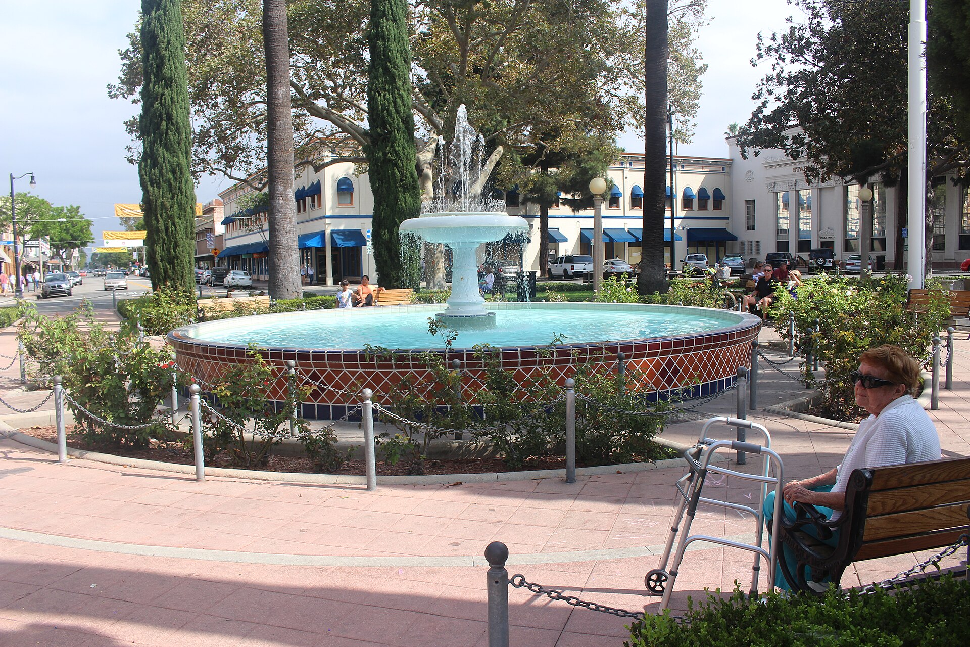 The fountain at the center of the Plaza in Old Towne Orange, surrounded by palm trees and storefronts