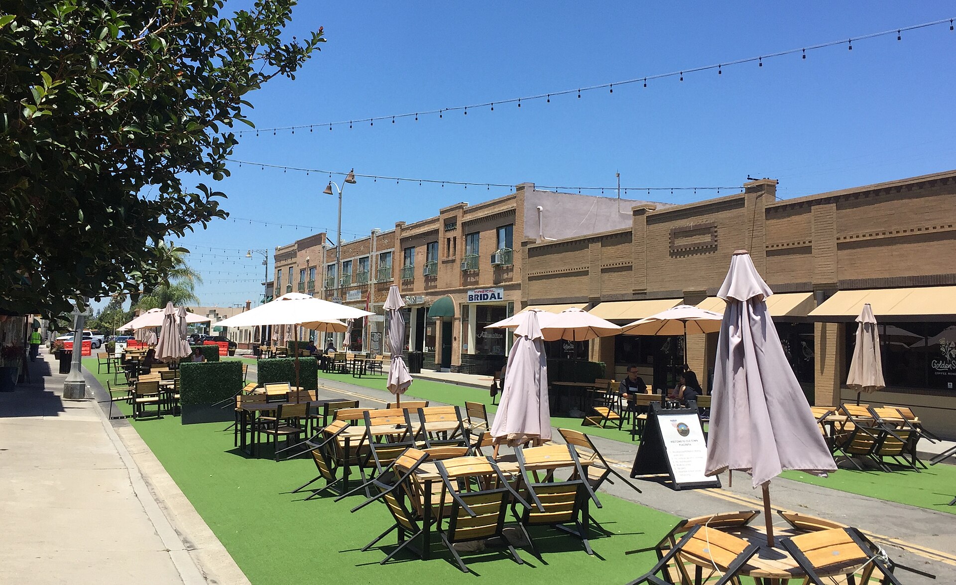 Outdoor seating with umbrellas and string lights at Placita Santa Fe in Old Town Placentia