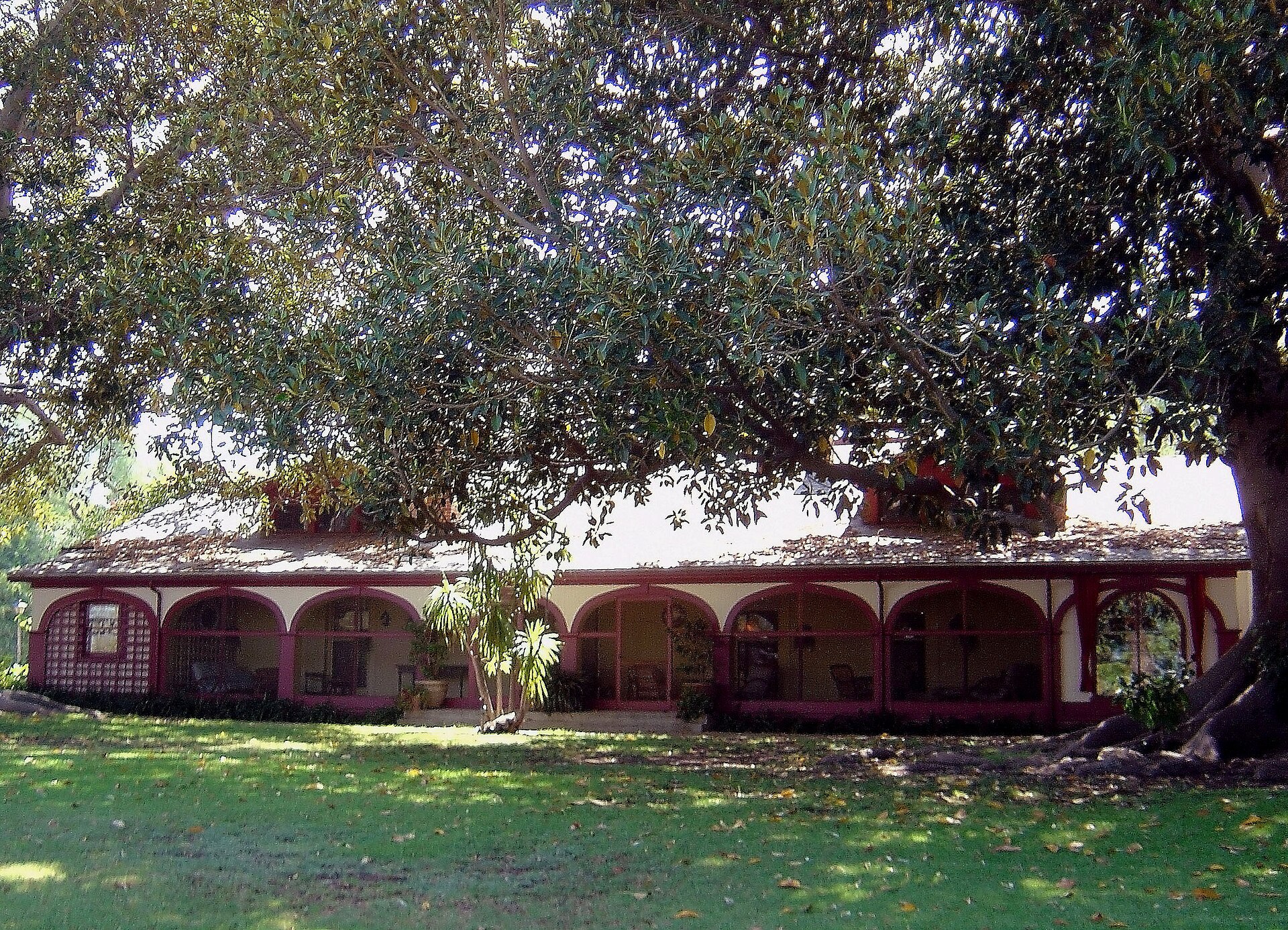 The adobe ranch house at Rancho Los Alamitos in Long Beach, shaded by large trees