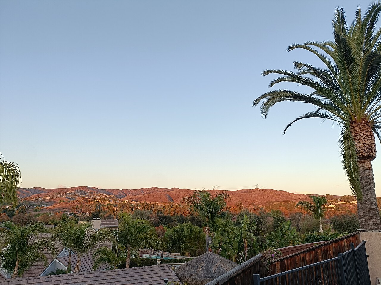 Hills above rooftops and palm trees in Yorba Linda in late-afternoon light